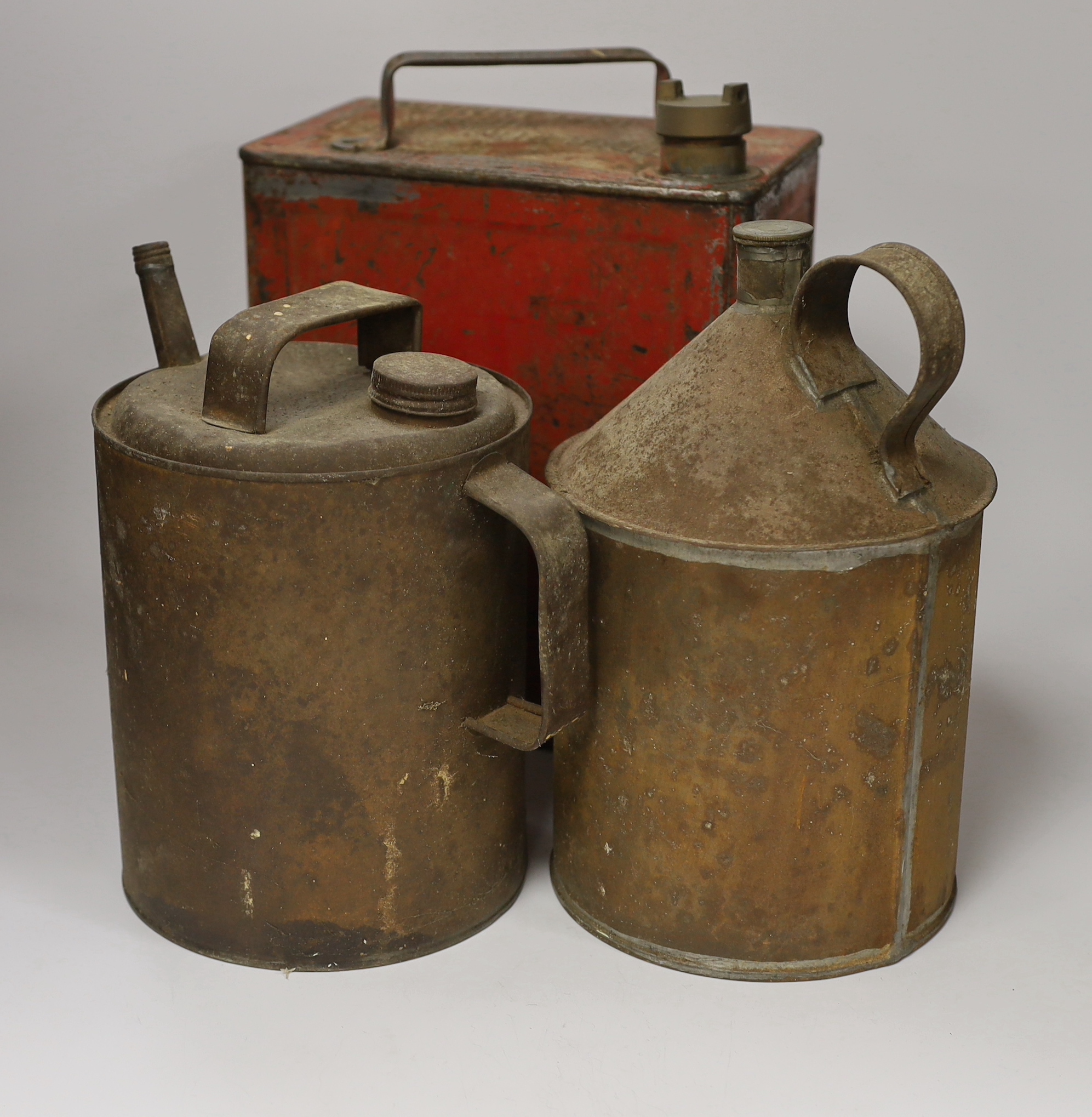 A 20th century red petrol can and two others, largest 32cm high